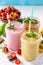 Strawberry, chocolate and apricot milkshake or smoothies on a white wooden background.