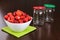 Strawberry cleared in a white bowl and empty jars