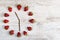 Strawberry clock with arrows from coffee beans, showing the time at eleven o`clock thirty minutes or twenty three hours thirty min