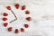 Strawberry clock with arrows from coffee beans, showing the time of seven hours fifty-five minutes or nineteen hours fifty-five mi