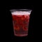 Strawberry cocktail isolated on a black background. Drink in a plastic glass