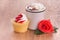 Strawberry cupcake with a cup of hot chocolate and a bright red rose