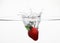 Strawberry dropping into water. Conceptual image shot