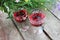 Strawberry elderflower cocktail, and wild blue and yellow flowers on the wooden board table. Two glasses of red wine with berries