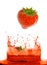 Strawberry falling in juice.