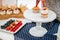 Strawberry filled cupcakes with creamy frosting on white serving platter, selective focus