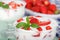 Strawberry flavored yoghurt with fresh berries and mint leaves.