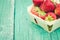 Strawberry. Fresh berries of strawberry on wooden green table/Selective focus. Strawberry in small basket on natural wooden