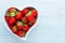 Strawberry heart. Fresh strawberries in plate on white wooden table. Top view, copy space