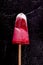 Strawberry ice cream popsicle lolly pops with whipped cream on black background. Top view