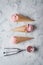 strawberry ice cream and waffle cone on marble background, top view