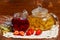 Strawberry jam in jar with fresh strawberries and teapot linden lavender tea and flowers on wooden background. Fresh