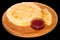 Strawberry jam on a stack of pancakes. Russian blini on black b