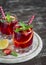 Strawberry lemonade with lemon and mint in glass beakers