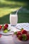 Strawberry, milk, ceramic jug and a glass of milk with a straw