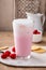 Strawberry milk drink with cold foam in a tall glass