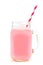 Strawberry milk in a mason jar with straw over white