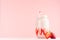 Strawberry milkshake with slices ripe berry in jar and straw on gentle pastel pink and white background, copy space.