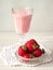 Strawberry milskhake in glass, strawberries cristal bowl on white. Healthy eating breakfast concept