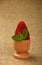 Strawberry and mint leaves in eggcup on canvas