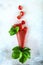 Strawberry pastille rolled into a cone. Strawberry berry on a light background with strawberry leaves. A pastille cone. Copy of