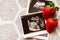 Strawberry and photos of a human fetus from ultrasound scan during pregnancy on right side gray background