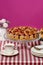 Strawberry pie on cake stand, fuchsia background