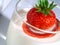 Strawberry plunging into glass of milk