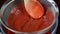 The strawberry puree is poured through a sieve.