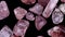 Strawberry quartz heap up jewel stones texture on black background. Moving right seamless loop backdrop