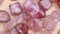 Strawberry quartz heap up jewel stones texture on light varnished wood background. Moving right seamless loop backdrop