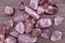 Strawberry quartz heap up stones texture on brown varnished wood background