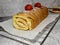 strawberry roll with a metal grill with baking paper and strawberries.close up. selective focus