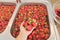 Strawberry season, washing berries in water in wash basin at home kitchen