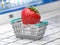 Strawberry in a shopping basket on laptop keyboard. Sex shop online or buying intimate content concept
