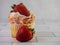 Strawberry shortcake cupcake, a yellow cupcake filled with strawberry jam, whipped cream swirled high and strawberry cake crumbles