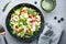 Strawberry, shrimp and herbs healthy salad with arugula, avocado and almond slices, gray kitchen table. Fresh useful dish for