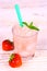 Strawberry slush in glass with straw and berries