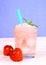 Strawberry slush in glass with straw on blue background