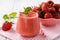 Strawberry smoothie in glass on wooden background.