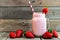 Strawberry smoothie in a mason jar over rustic wood