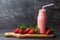 Strawberry smoothie or milkshake in jar on black rustic background, healthy food for breakfast