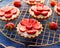 Strawberry tarts, small shortbread tarts with the addition of cream cheese, fresh strawberries  on a cooling tray