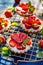 Strawberry tarts, small shortcrust tarts with the addition of cream cheese, fresh strawberries and mint on cooling tray on a dark