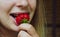 Strawberry. The taste of food. Happy girl tastes strawberries. Close up of female lips tasting strawberries