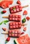 Strawberry watermelon ice cream popsicles with mint over steel tray background