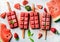 Strawberry watermelon ice cream popsicles with mint over steel tray background