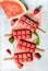 Strawberry watermelon ice cream popsicles with mint over steel tray background