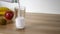 Strawberry yogurt is poured into a glass on wooden table