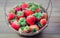 Strawberrys berries in a basket on the wooden floor.